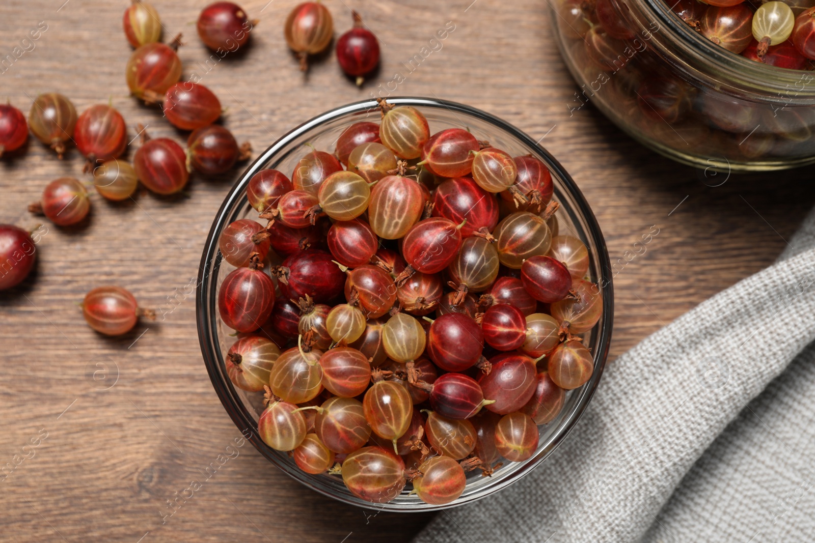 Photo of Many fresh ripe gooseberries on wooden table, flat lay