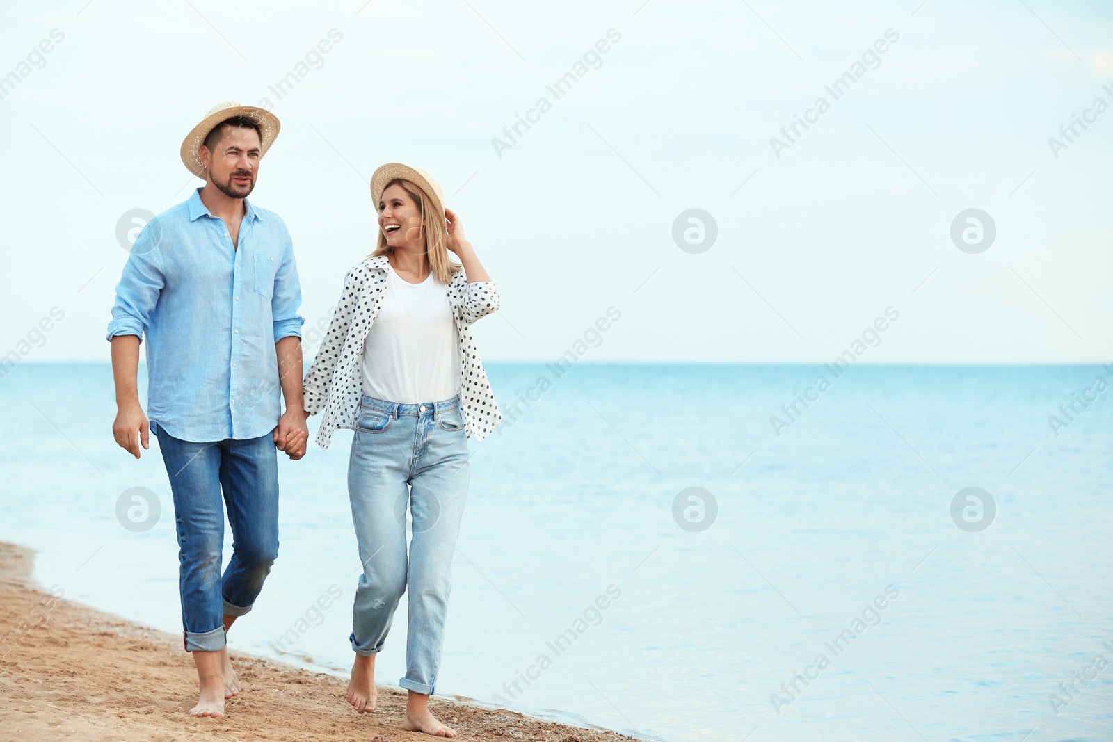 Photo of Happy romantic couple walking on beach, space for text
