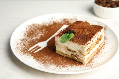 Photo of Plate of tiramisu cake on white table