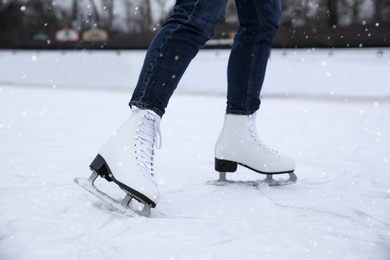 Woman skating along ice rink outdoors, closeup