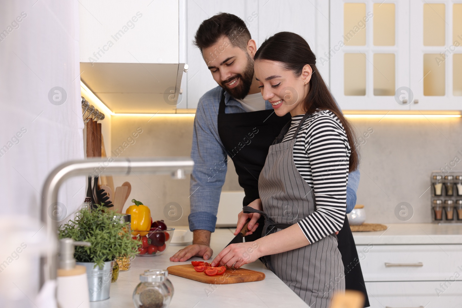 Photo of Happy lovely couple cooking together in kitchen