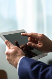 Photo of Closeup view of man using new tablet indoors