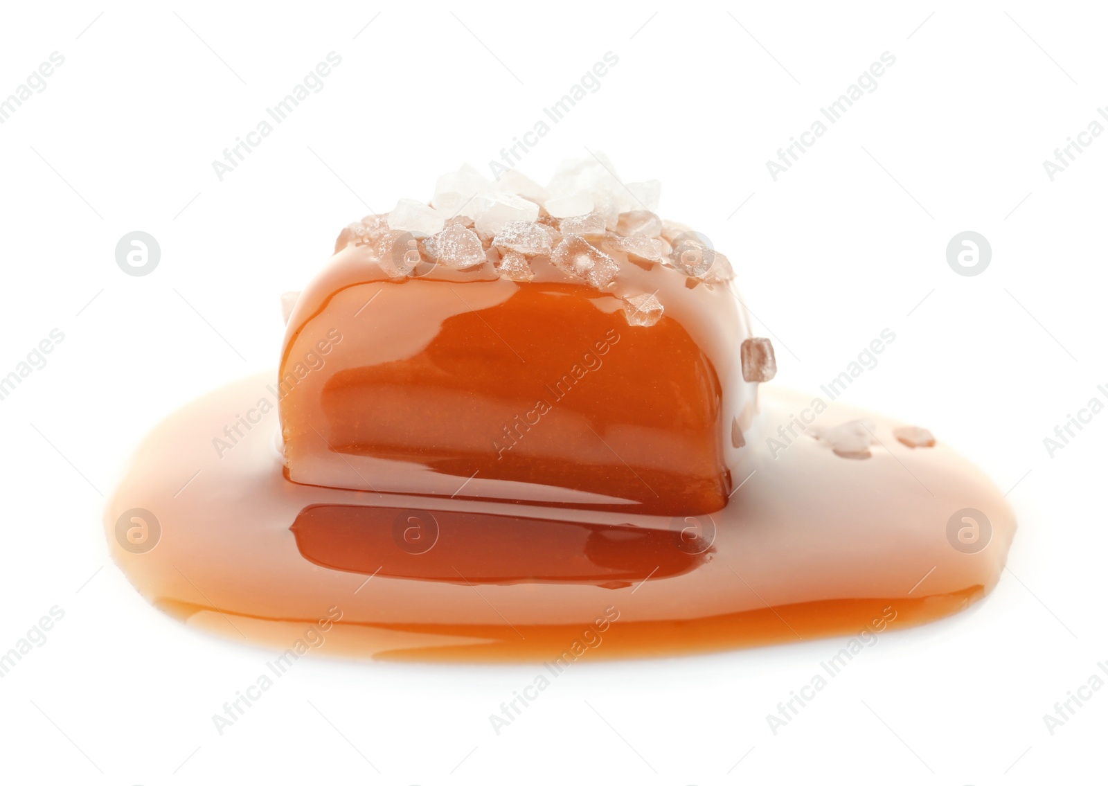 Photo of Delicious candy with caramel sauce and salt on white background