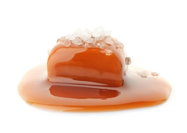 Photo of Delicious candy with caramel sauce and salt on white background