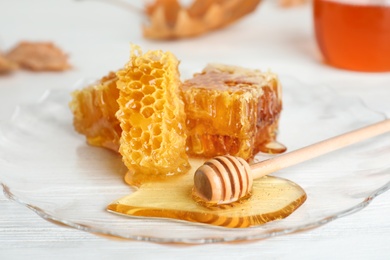 Photo of Plate with honeycomb pieces and dipper on table