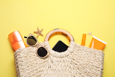 Photo of Flat lay composition with sun protection products and beach accessories on yellow background