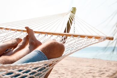 Young couple relaxing in hammock on beach, closeup