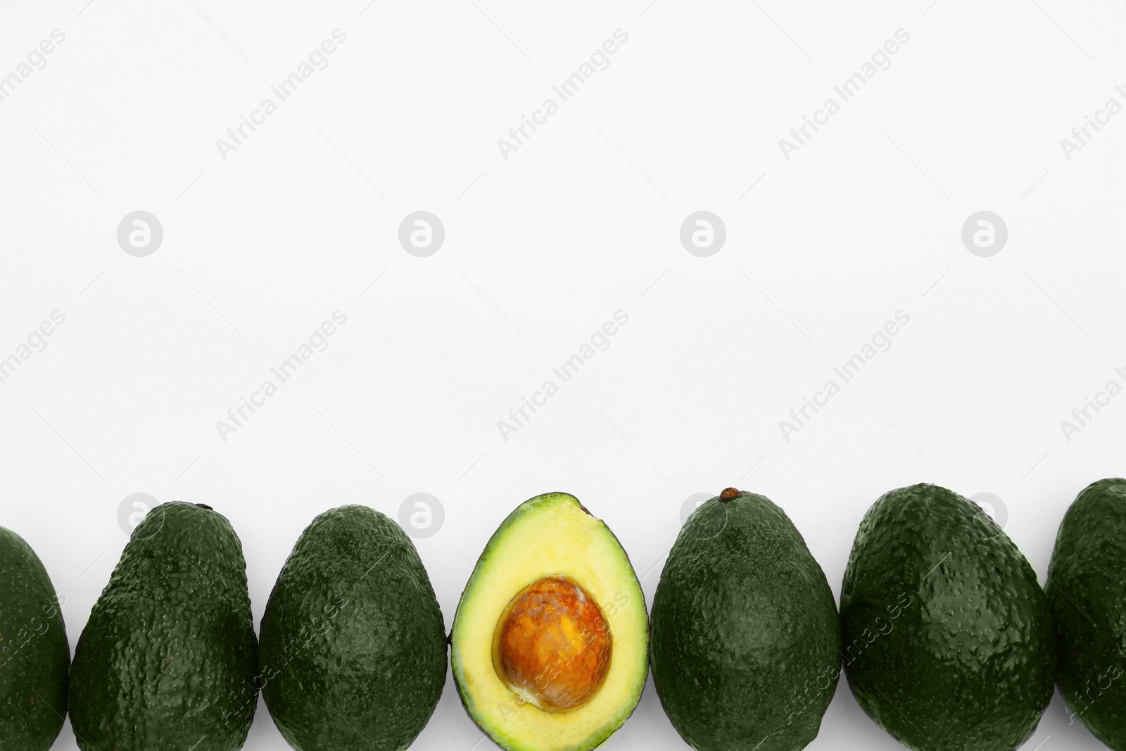 Photo of Tasty whole and cut avocados on white background, flat lay. Space for text