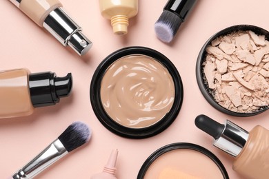 Photo of Liquid foundations, beauty accessories and face powders on beige background, flat lay