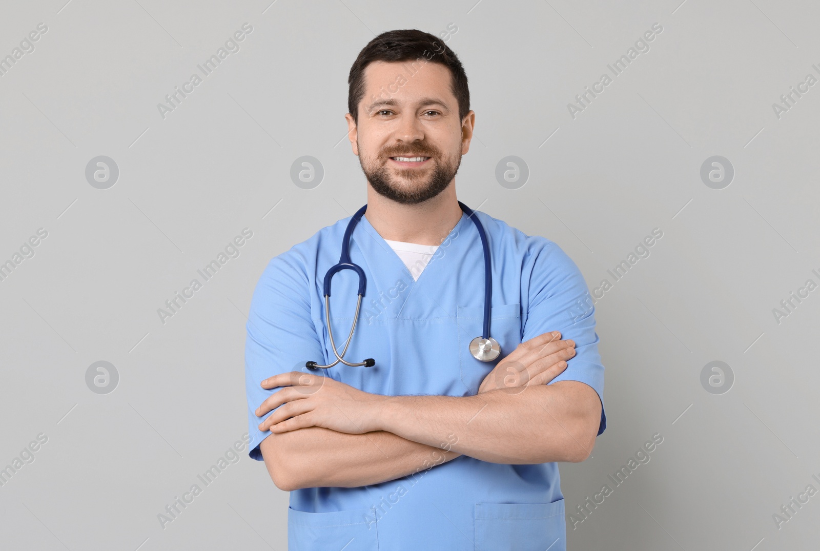 Photo of Portrait of smiling doctor on light grey background