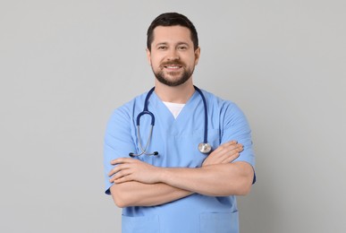 Portrait of smiling doctor on light grey background