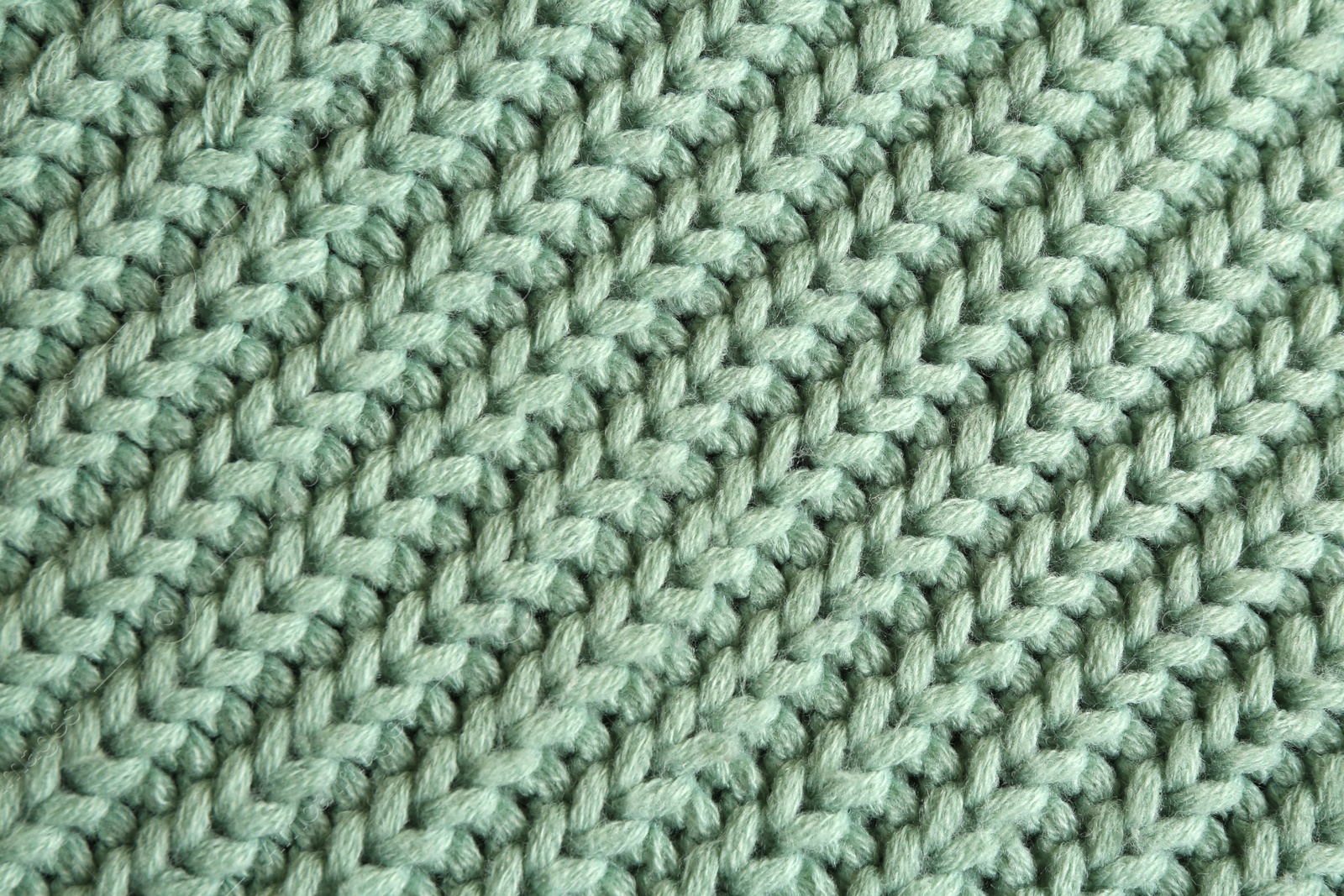 Photo of Beautiful pale green knitted fabric as background, top view