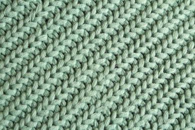 Beautiful pale green knitted fabric as background, top view
