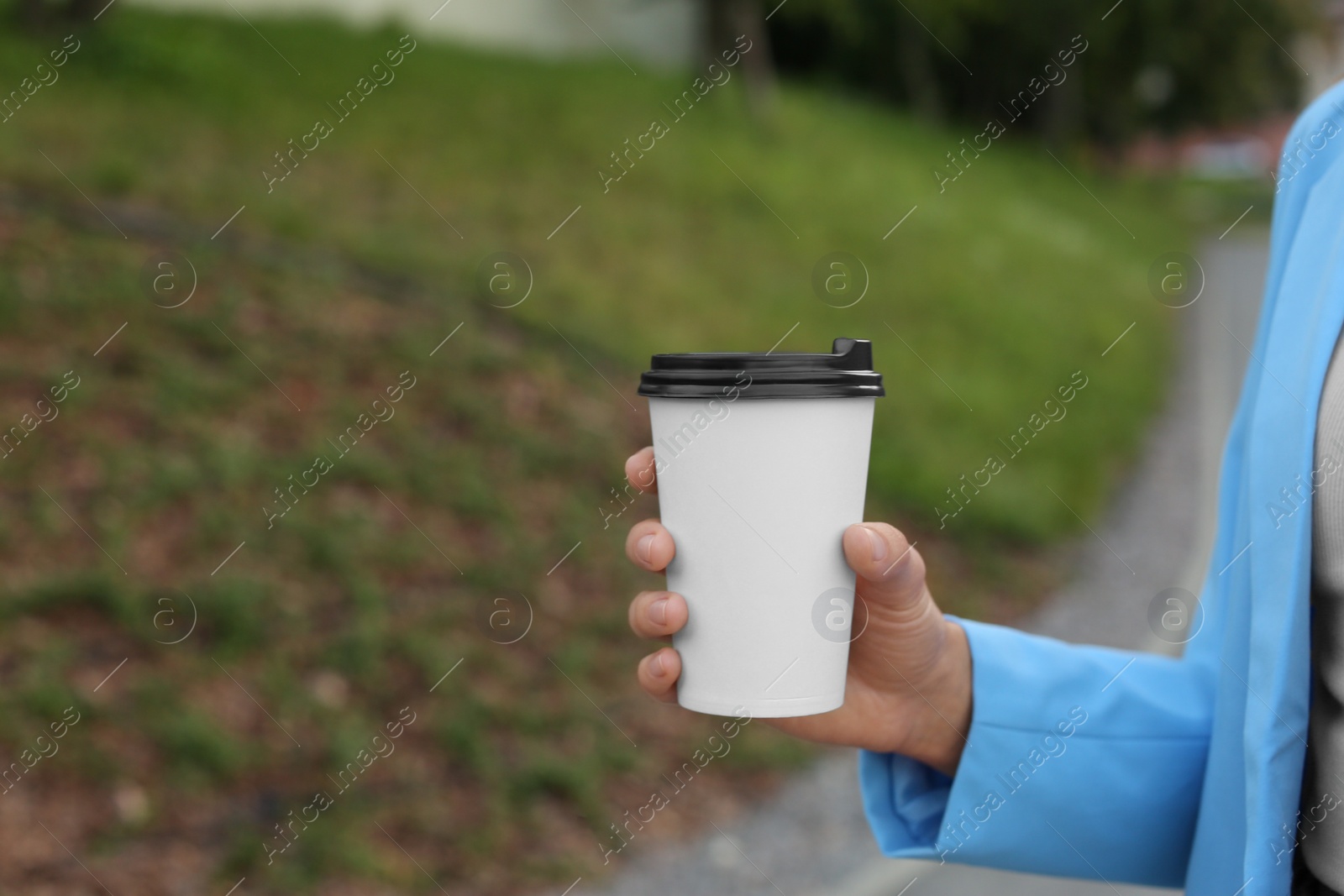 Photo of Coffee to go. Woman with paper cup of drink outdoors, closeup. Space for text