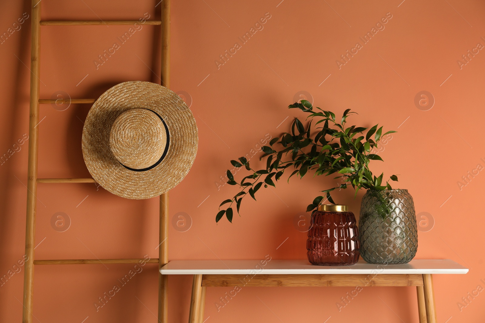 Photo of Stylish decorative vases on table near wall