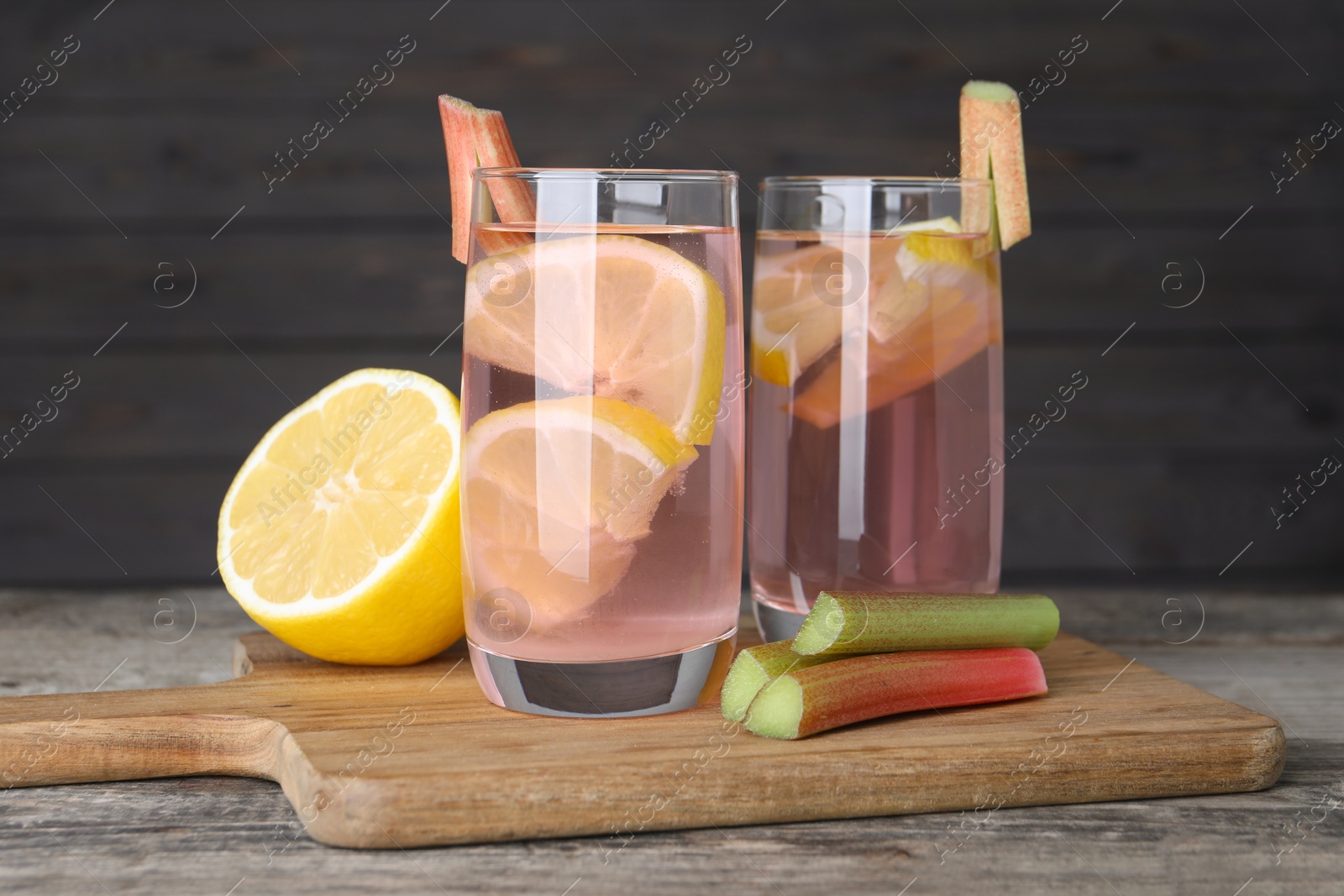 Photo of Tasty rhubarb cocktail with lemon on wooden table