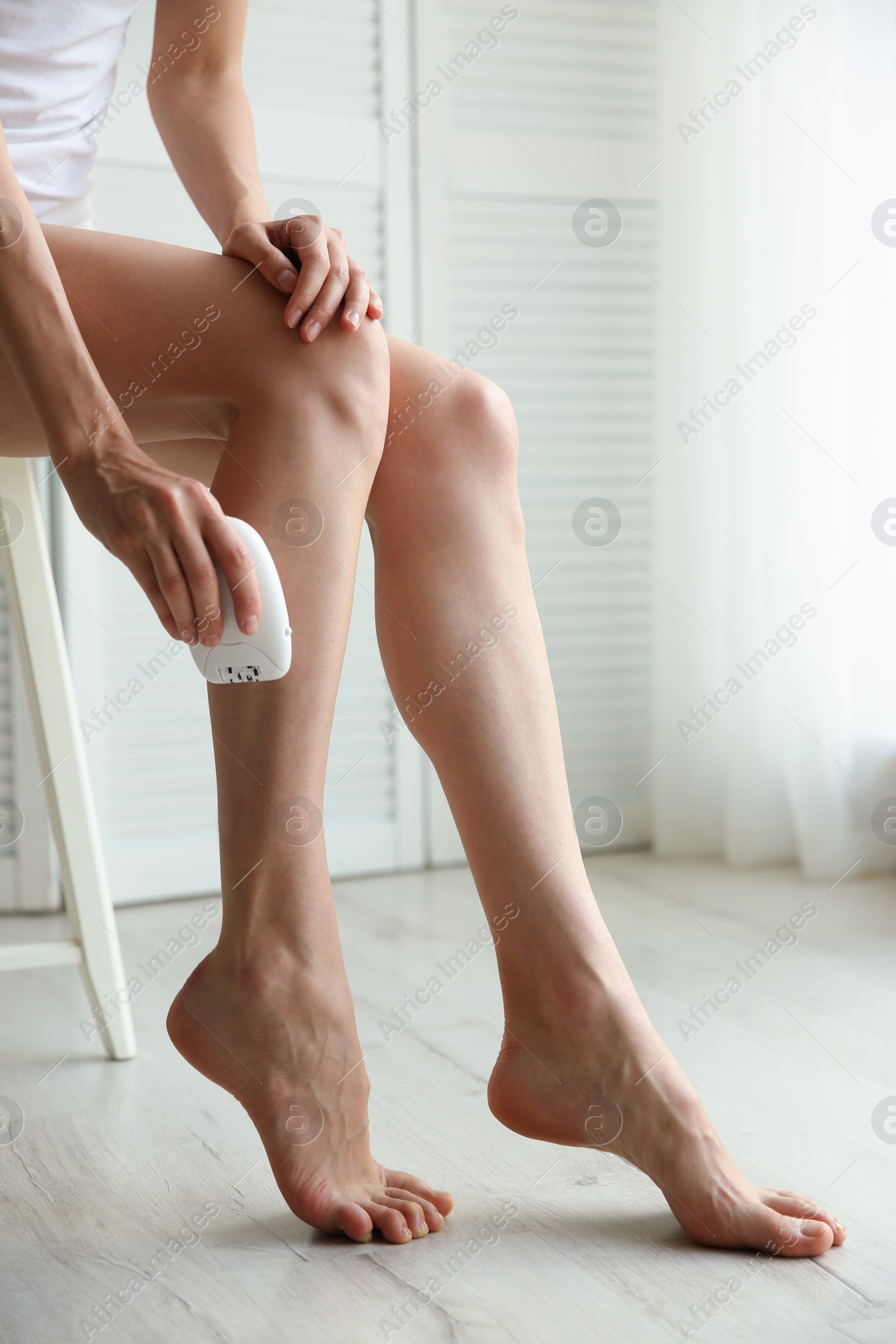 Photo of Woman doing leg epilation procedure indoors, closeup