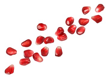 Image of Ripe juicy pomegranate seeds falling on white background