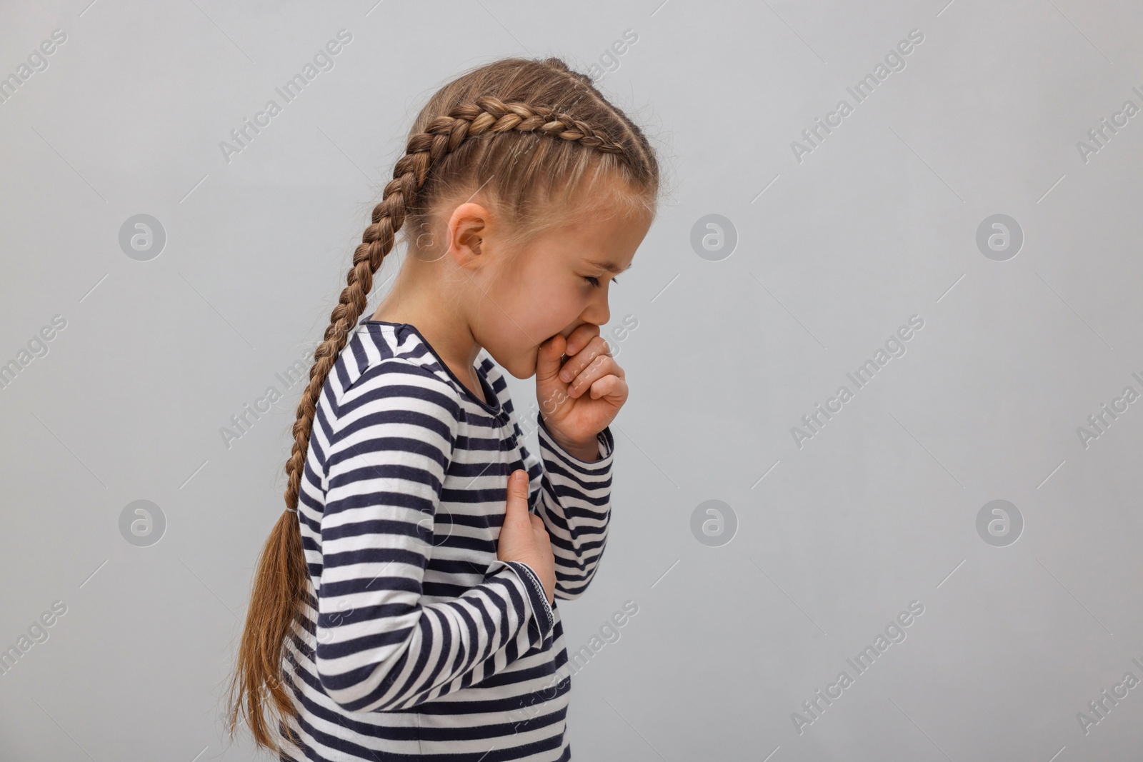 Photo of Sick girl coughing on gray background. Cold symptoms