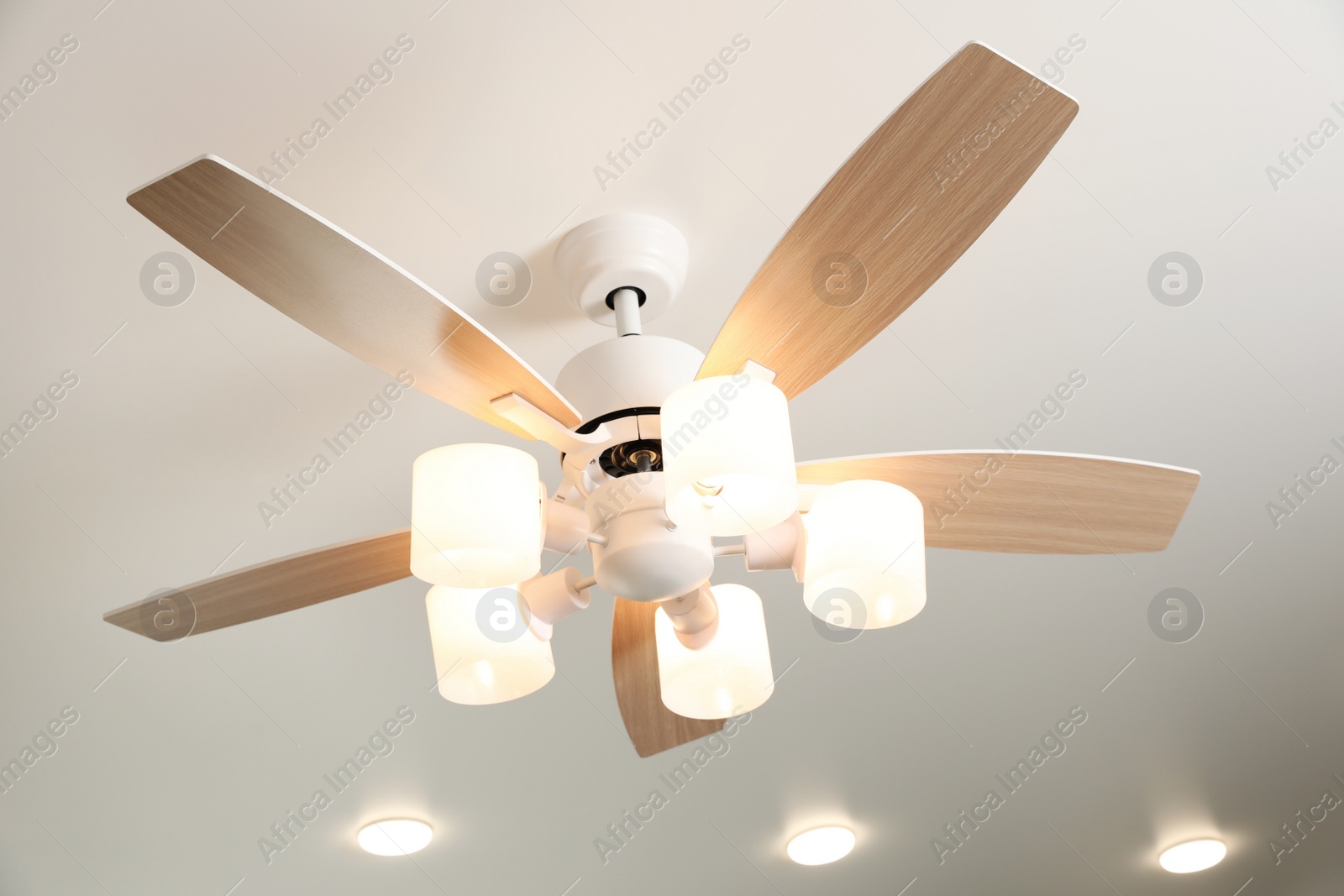 Photo of Modern ceiling fan with lamps indoors, below view