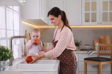Photo of Mother and her cute little baby spending time together in kitchen