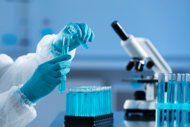 Scientist working with test tubes in laboratory, closeup