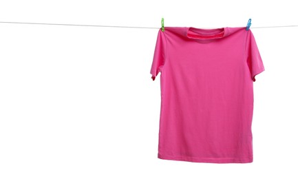 Pink t-shirt drying on washing line against white background