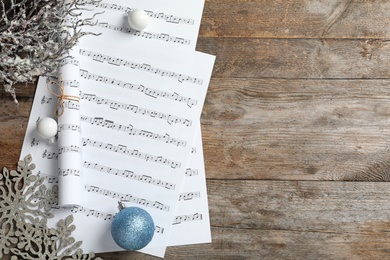 Photo of Flat lay composition with Christmas decorations and music sheets on wooden background