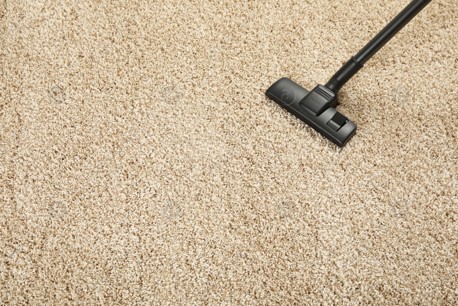 Photo of Removing dirt from beige carpet with modern vacuum cleaner, above view. Space for text