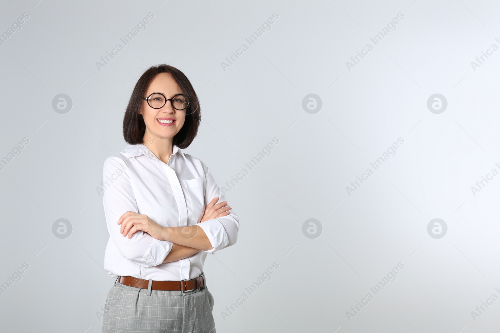 Photo of Portrait of mature businesswoman on light grey background. Space for text