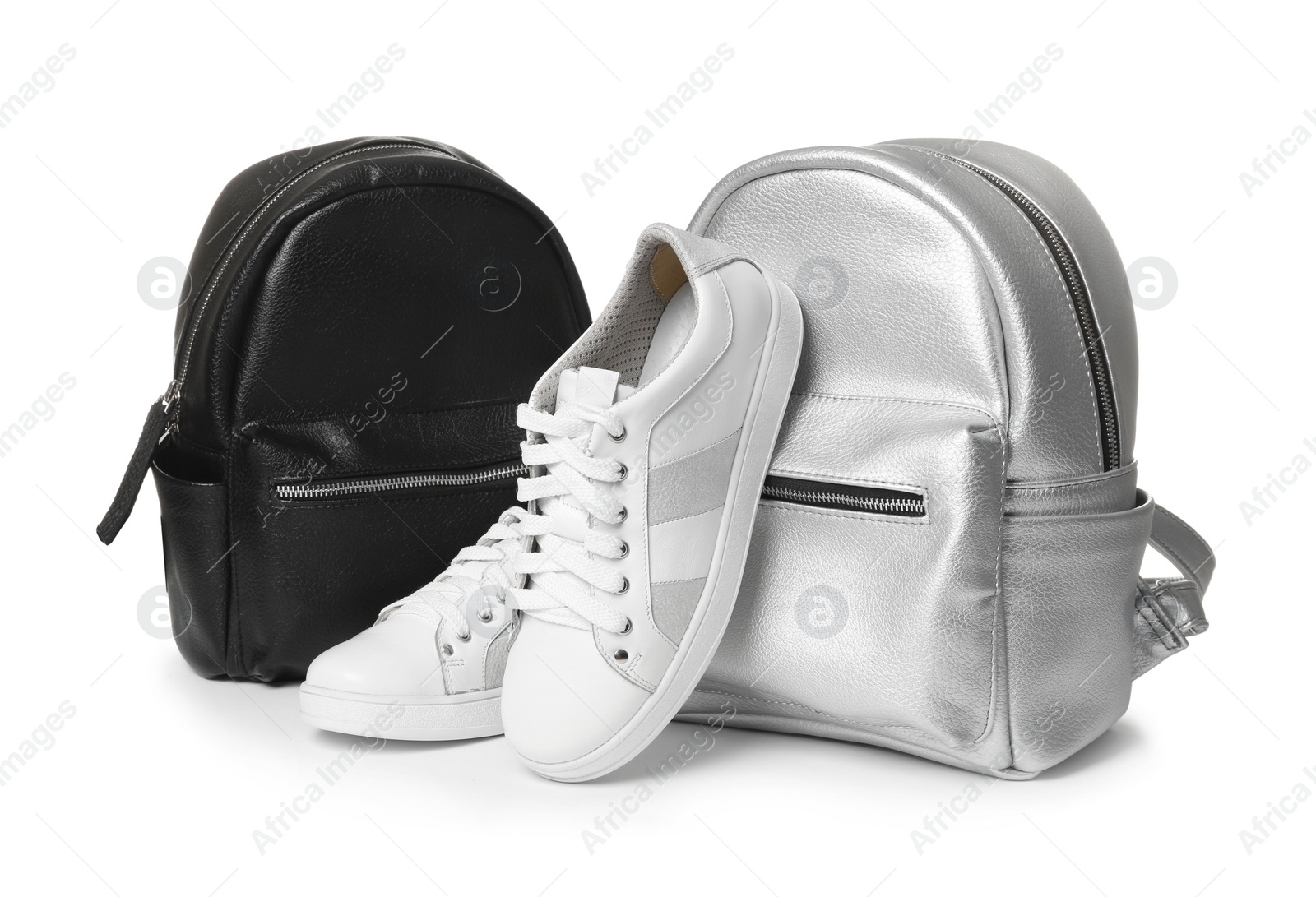 Photo of Pair of modern shoes and stylish backpacks on white background