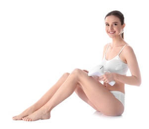 Young woman doing leg epilation procedure on white background