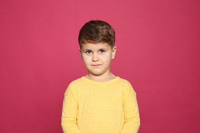 Portrait of cute little boy on color background