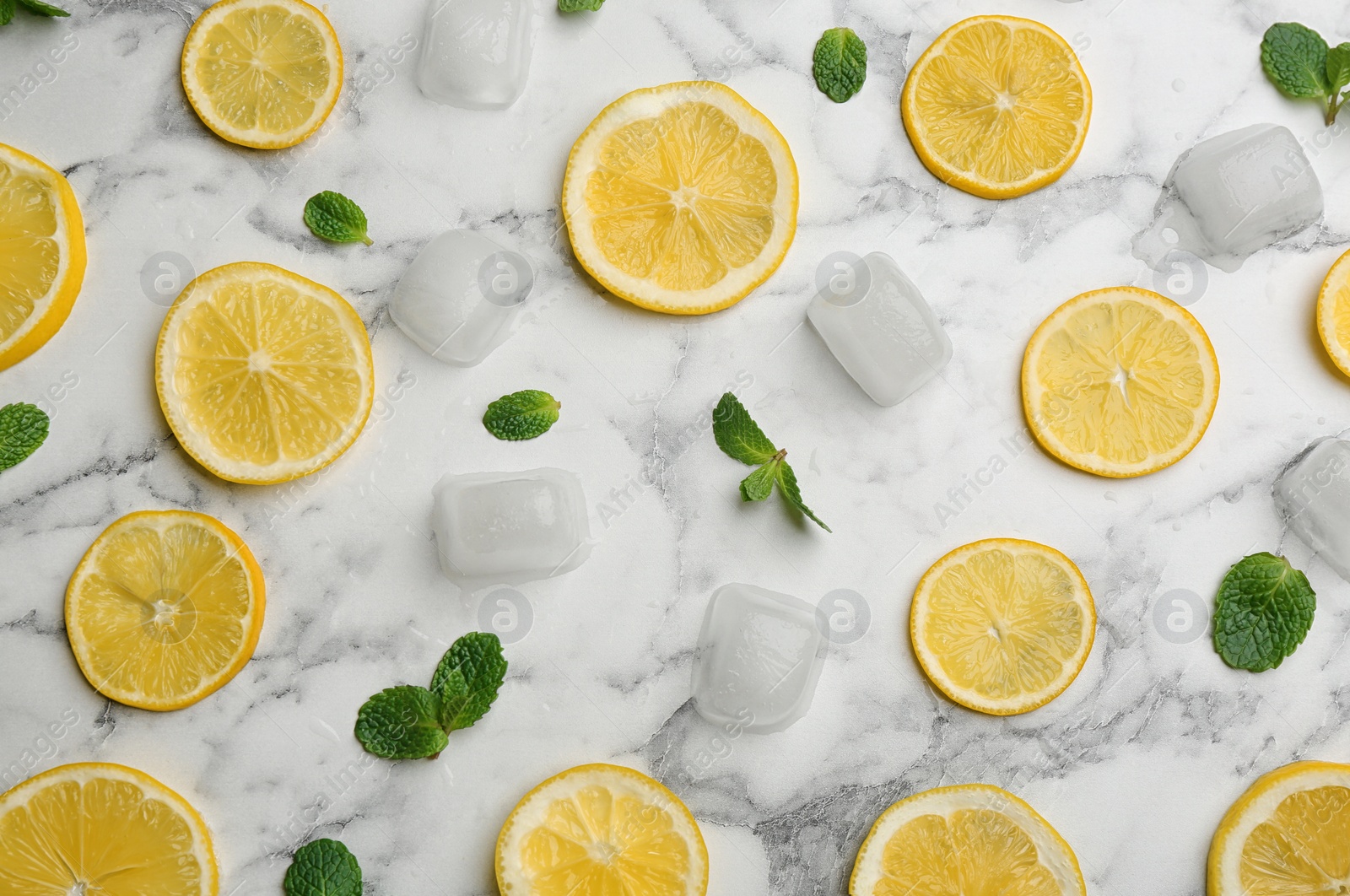 Photo of Lemonade layout with juicy lemon slices, mint and ice cubes on white marble table, top view