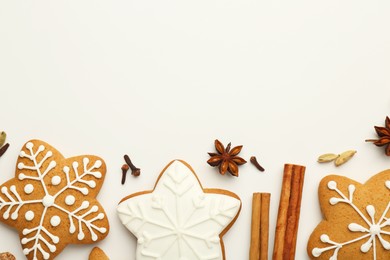 Tasty Christmas cookies with icing and spices on white background, flat lay. Space for text