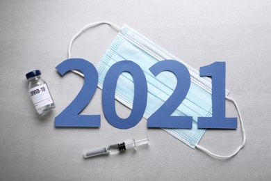 Photo of Flat lay composition with coronavirus vaccine and number 2021 on grey background