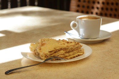 Photo of Piece of delicious cake and coffee on beige table, closeup