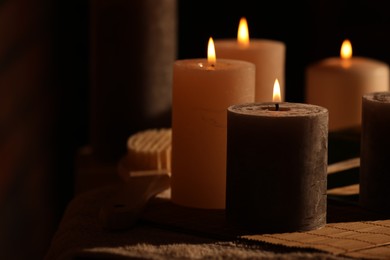 Photo of Spa composition with burning candles on massage table in wellness canter, space for text