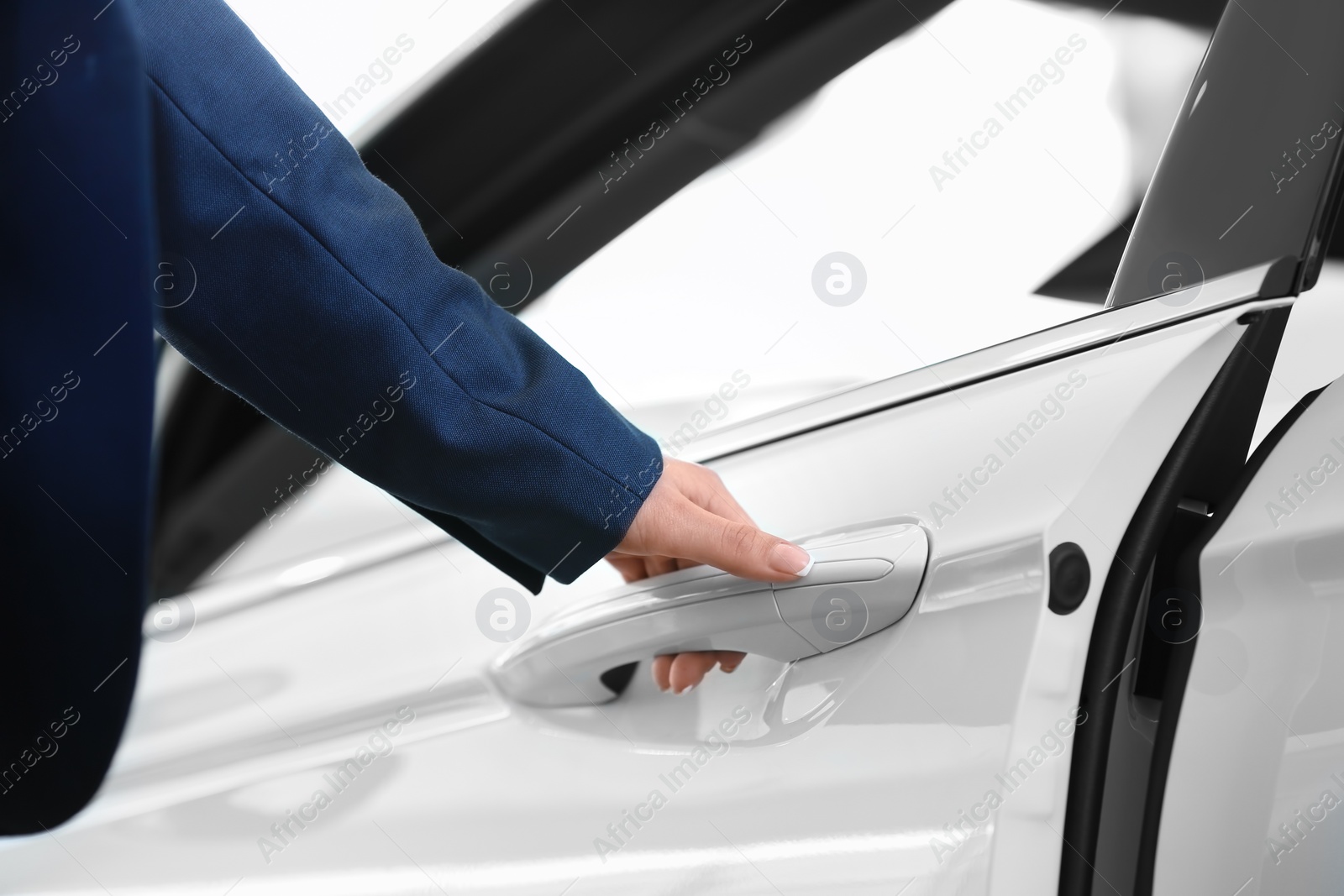 Photo of Young woman opening door of new car, closeup