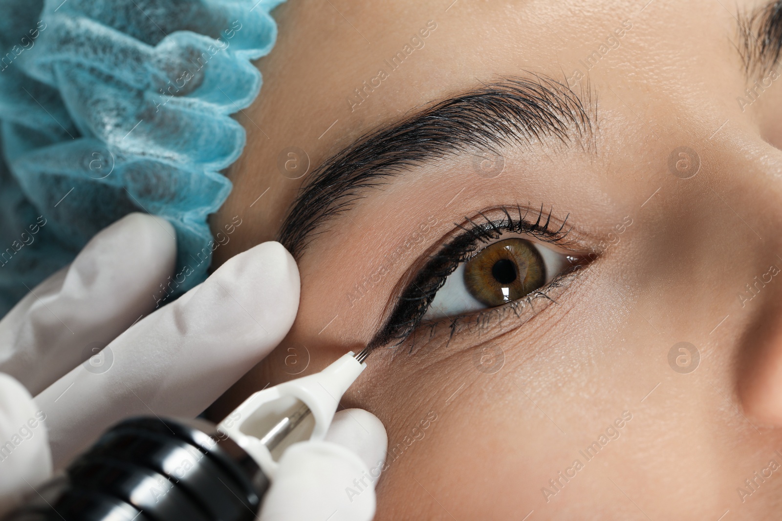 Photo of Young woman undergoing procedure of permanent eyeliner makeup, closeup