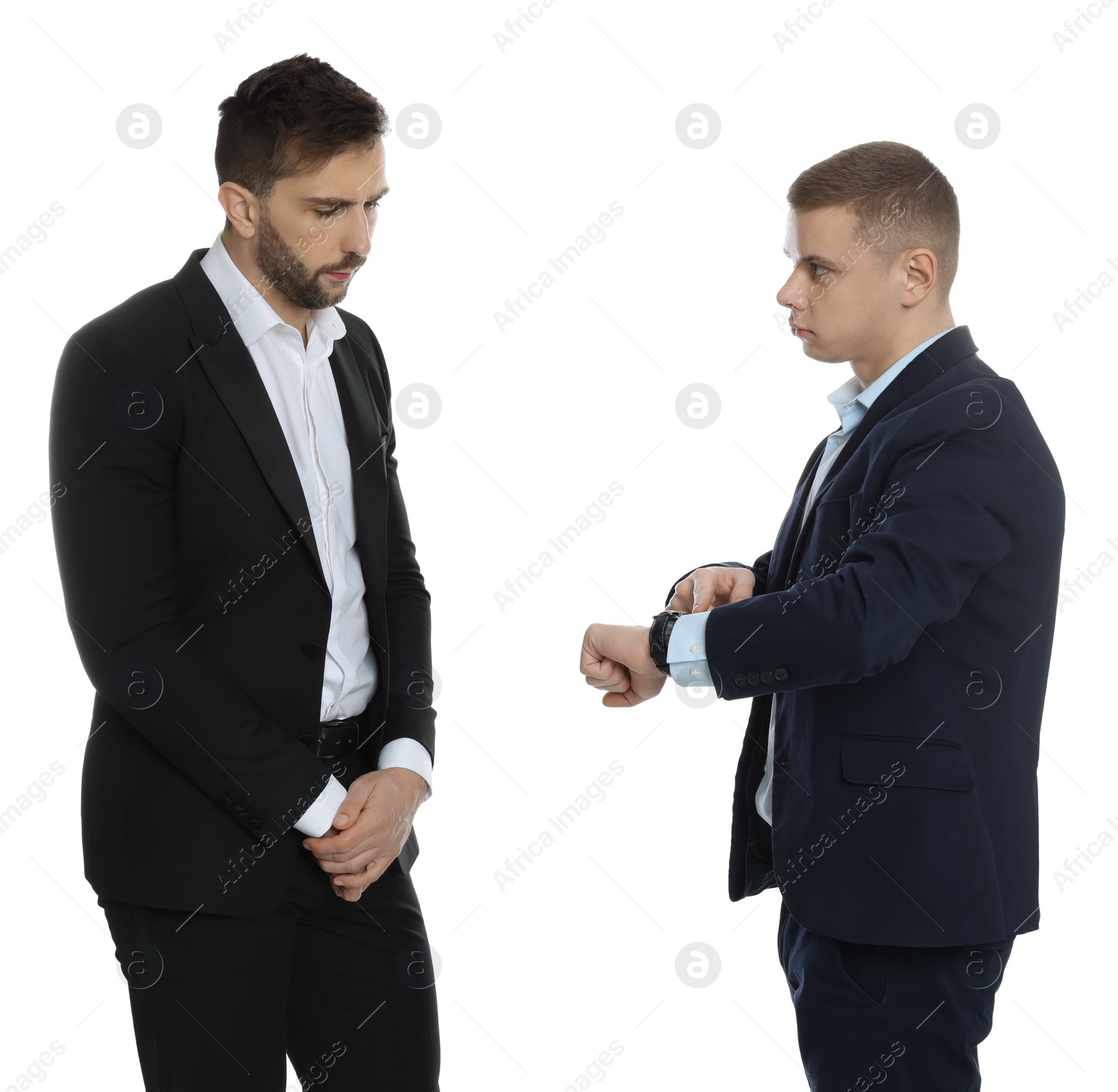 Photo of Businessman pointing on wrist watch while scolding employee for being late against white background