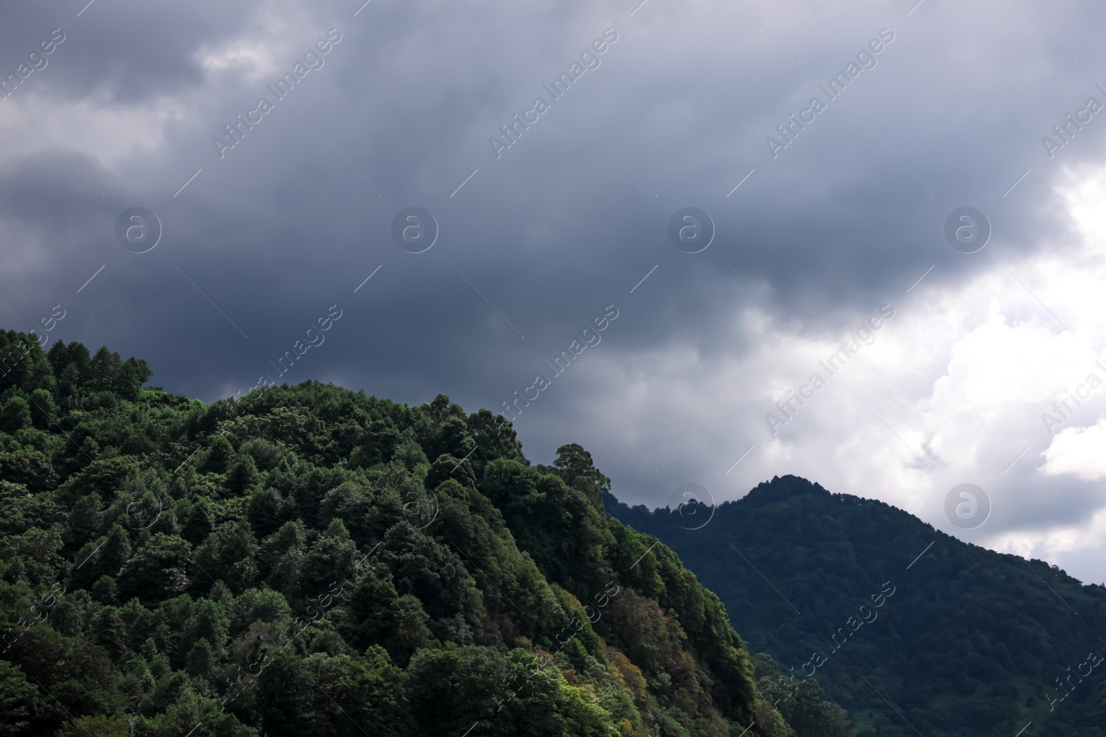 Photo of Picturesque view of mountains under beautiful gloomy sky with fluffy clouds