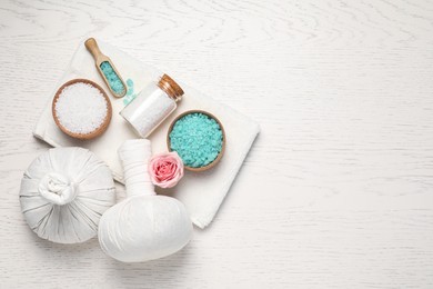 Flat lay composition of herbal bags and spa products on white wooden table, space for text