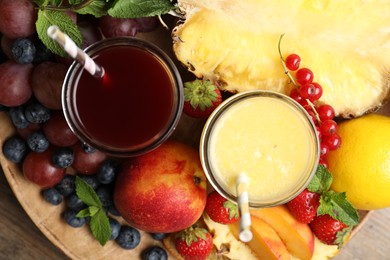 Delicious colorful juices in glasses and fresh ingredients on wooden table, top view