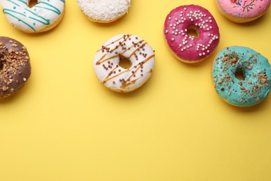 Tasty glazed donuts on yellow background, flat lay. Space for text