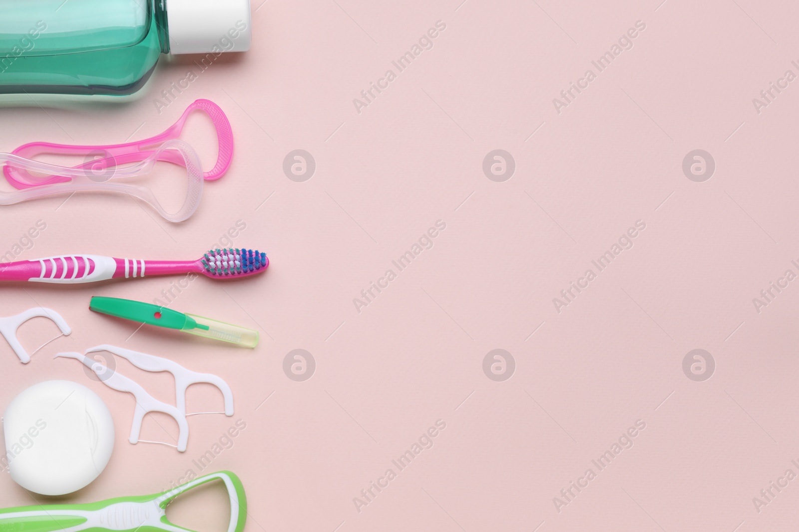 Photo of Tongue cleaners and other oral care products on pink background, flat lay. Space for text