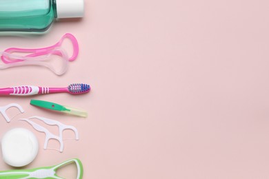 Photo of Tongue cleaners and other oral care products on pink background, flat lay. Space for text