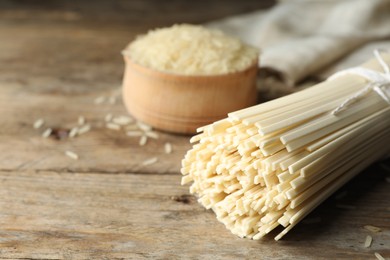 Photo of Raw rice noodles on wooden table, closeup