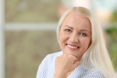 Portrait of beautiful older woman against blurred background with space for text