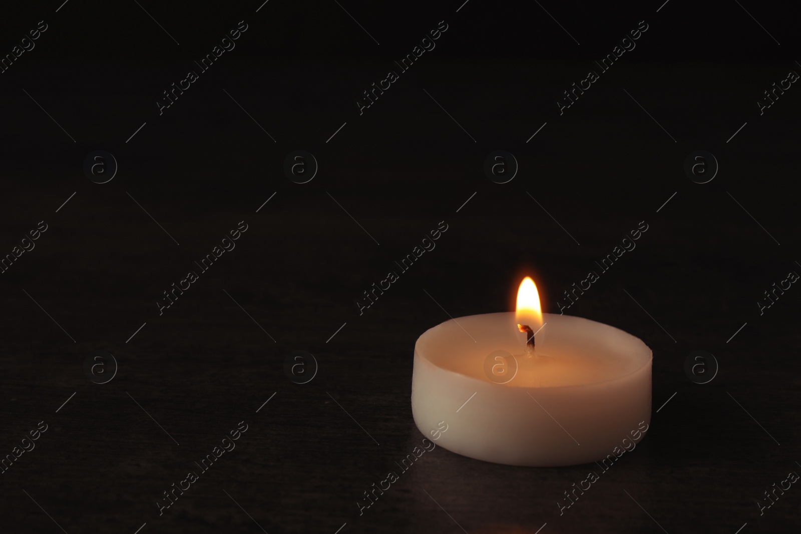 Photo of Burning candle on dark background, space for text. Symbol of sorrow